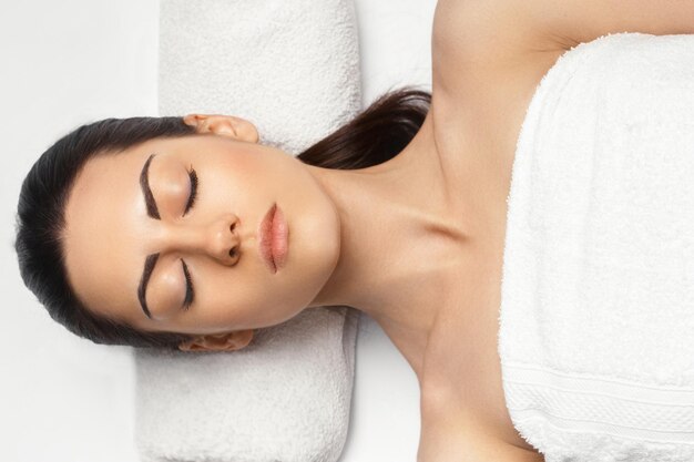 Masaje facial Primer plano de una mujer joven que recibe un tratamiento de masaje spa en el salón de belleza spa Piel spa