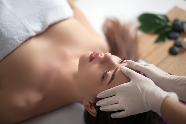 Masaje facial. Primer plano de una mujer joven recibiendo tratamiento de spa.