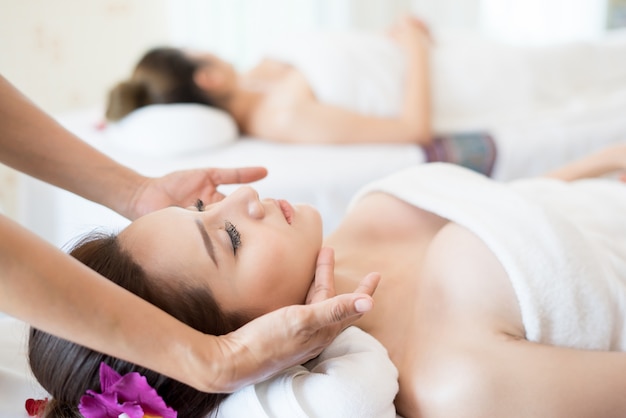 Masaje oriental tradicional y tratamientos de belleza. Hermoso joven tiene mujer de masaje en el salón de spa.