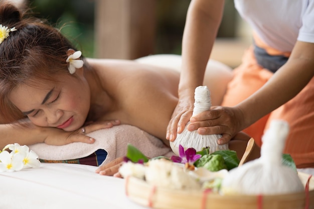 Masaje spa tratamiento relajante del síndrome de la oficina estilo de masaje tailandés tradicional Masaje femenino asiático compresa tradicional para masaje caliente dolor de espalda dolor en el brazo y estrés para la mujer cansada del trabajo