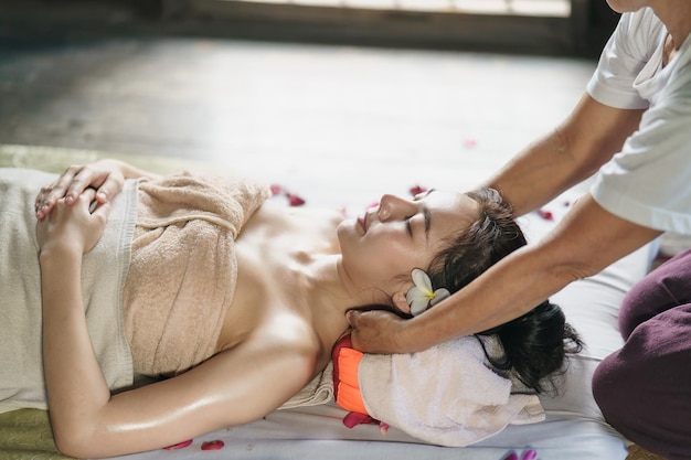 Masaje y spa tratamiento relajante del síndrome de la oficina estilo de masaje tradicional tailandés Masajista femenina de Asain que hace masajes para tratar el dolor de espalda dolor en el brazo y estrés para la mujer de la oficina cansada del trabajo