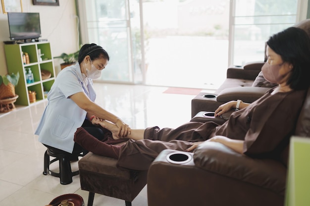 Masaje spa tratamiento relajante síndrome de la oficina masaje tailandés tradicional Mujer mayor asiática medicina tradicional tailandesa con máscara masaje tratar dolor de espalda dolor de brazo dolor de pie pies y estrés