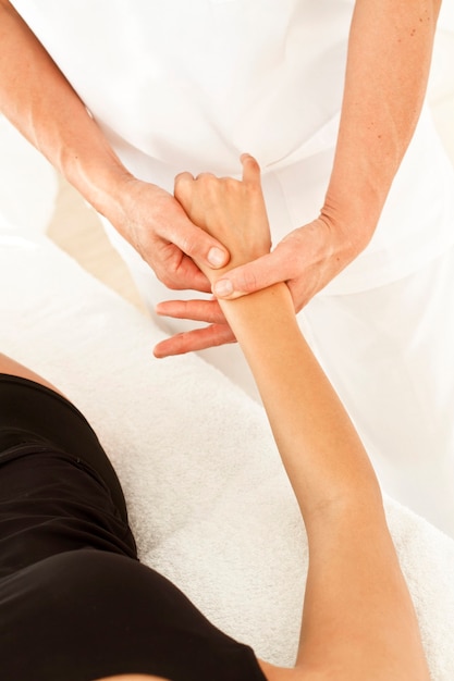 Foto masajes profesionales a una mujer en su mano y brazo.