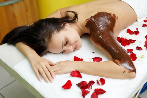 Masajista aplicando chocolate al brazo de la mujer