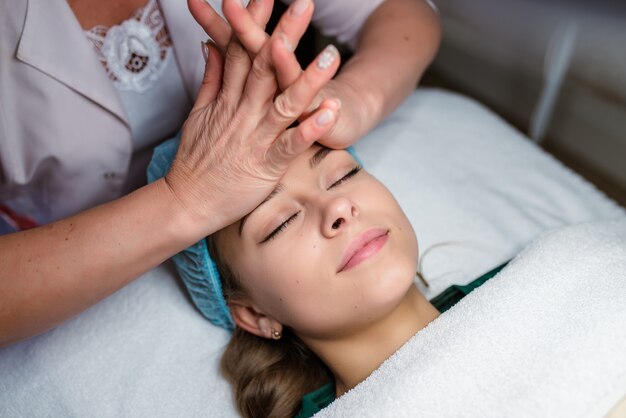 Masajista haciendo masaje en el cuerpo de la mujer en el salón de spa