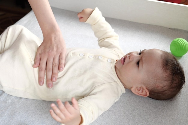 Masajista masajeando la barriga del bebé durante el cólico