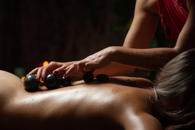 Masajista profesional masajeando a una clienta que trabaja en el centro de spa. Mujer hermosa joven relajante