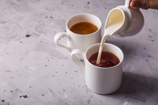 Foto masala chá em xícaras minimalistas brancas sobre uma mesa cinza