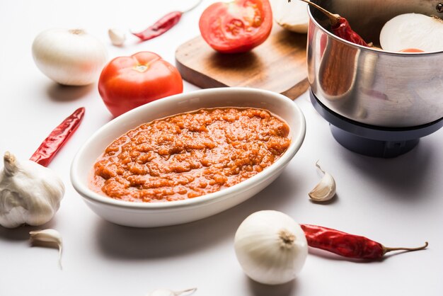 Masala de tomate de cebola ou purê para molho indiano, servido em uma tigela com tamatar cru, pays e lehsun e pimenta vermelha,