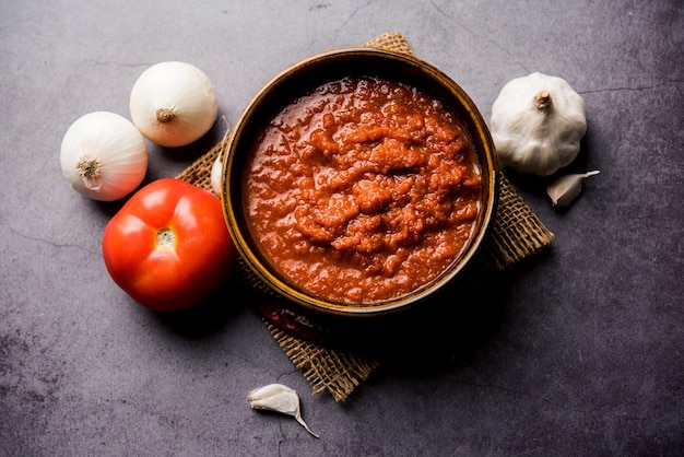 Masala de tomate de cebola ou purê para molho indiano, servido em uma tigela com tamatar cru, pays e lehsun e pimenta vermelha,