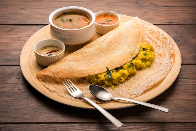 Masala dosa es una comida del sur de la India que se sirve con sambhar y chutney de coco. Enfoque selectivo