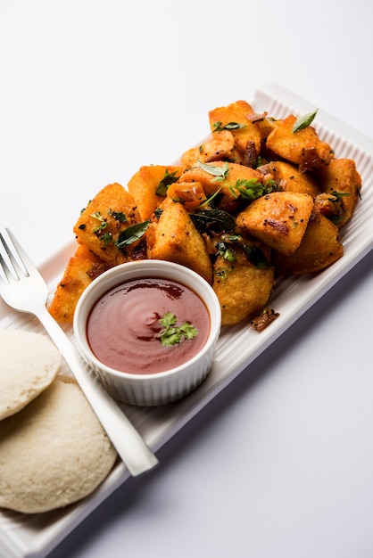 Masala Fried Idlies: refrigerio del sur de la India hecho con sobras y servido con salsa de tomate. enfoque selectivo