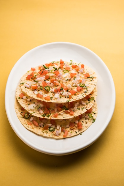 Masala Papad oder Papadum ist ein köstlicher indischer Snack aus geröstetem oder gebratenem Papad mit einer würzigen Zwiebel-Tomaten-Mischung