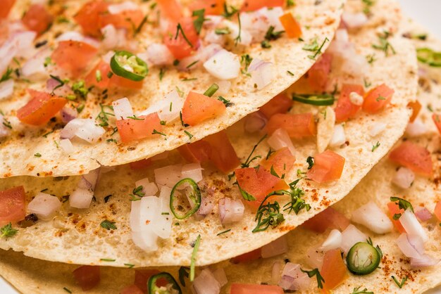 Masala Papad orÃ‚Â papadumÃ‚Â es un delicioso refrigerio indio elaborado con papad asado o frito cubierto con una mezcla de tomate cebolla picante y picante