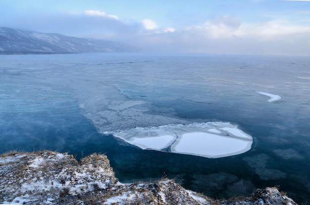 Las masas de hielo flotante de hielo que flotan en la niebla riegan en el lago Baikal. Puesta de sol