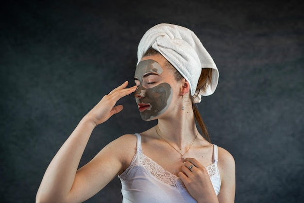 Foto máscara de arcilla de belleza verde en el rostro femenino aislada en negro tratamiento antienvejecimiento para el cuidado de la piel