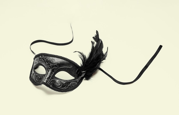 Máscara de carnaval con decoración de plumas negras aisladas en blanco