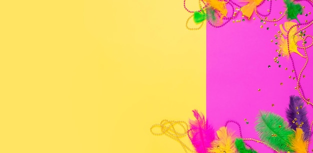 Máscara de carnaval plumas de colores cuentas de lentejuelas tradicionales para el festival Mardi Gras sobre fondo amarillo púrpura