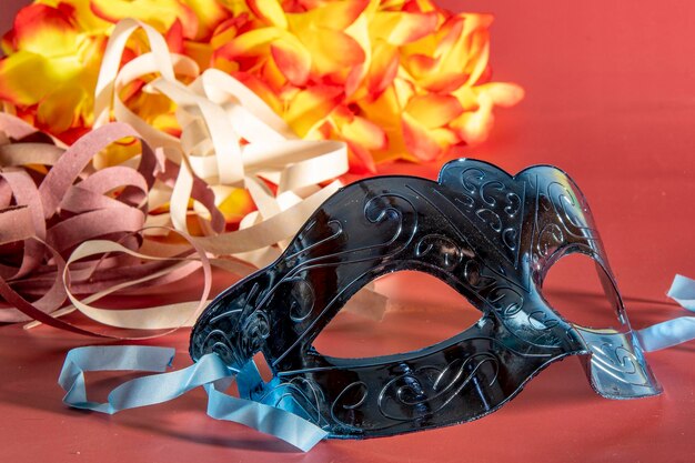 Máscara de carnaval veneciana con plumas y elementos típicos en el fondo