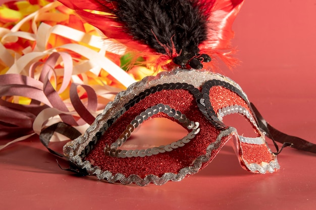 Máscara de carnaval veneciano con plumas y elementos típicos de fondo