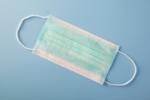 Máscara com alças de borracha. Máscara cirúrgica típica de 3 camadas para cobrir a boca e o nariz. Máscara de procedimento de bactérias. Conceito de proteção.