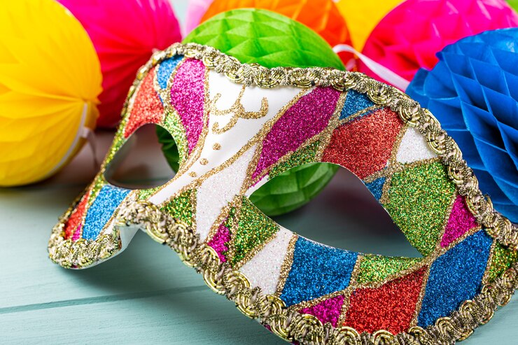Foto máscara de carnaval colorida e bolas de peper na superfície azul. conceito de cartão de felicitações para aniversário, carnaval, festa, convite
