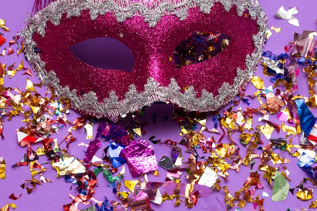 Máscara de carnaval colorida no fundo rosa com vários enfeites