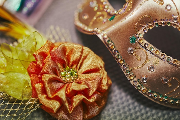 Máscara de carnaval em processo de decoração e broche decorativo em tecido e penas para deco