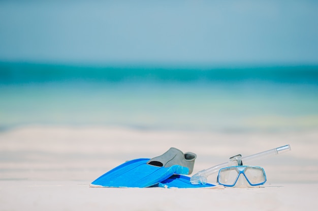 Máscara de equipamento de snorkel, snorkel e barbatanas na praia branca