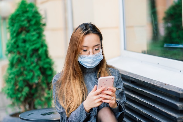 Máscara de proteção contra a propagação do vírus da gripe contra doenças e vírus da gripe. mulher asiática usando máscara cirúrgica no rosto em espaços públicos. cuidados de saúde.