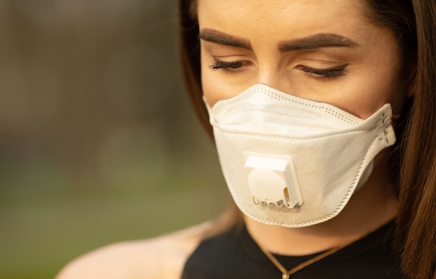 Foto máscara de proteção contra vírus da gripe protetora contra vírus e doenças da gripe. mulher usando máscara facial em espaços públicos.