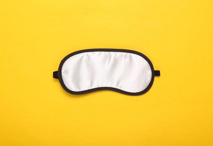 Máscara para dormir sobre fondo amarillo Vista superior plana Conceptos de sueños vívidos Accesorios para dormir Estilo minimalista