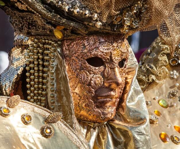 Máscara dourada com decorações e esculturas, venezia.