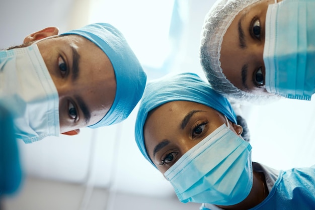 Máscara facial cirúrgica e equipe de cirurgiões durante o trabalho ambicioso em operação médica para ajuda de saúde hospitalar Colaboração de trabalho em equipe de médicos de suporte de emergência e visão inferior de homens e mulheres ajudando