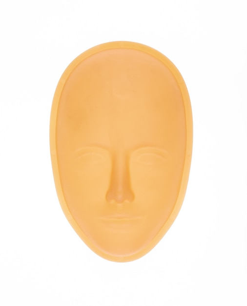 Máscara facial de plástico naranja sobre un fondo blanco