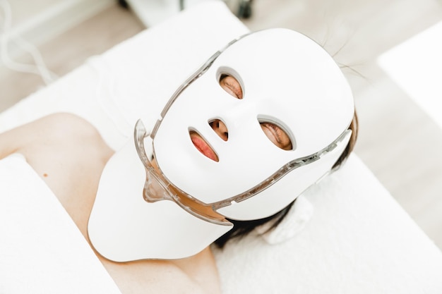 Máscara fotônica saúde e beleza procedimento cosmético para o rosto de uma mulher máscara facial led terapia fotônica