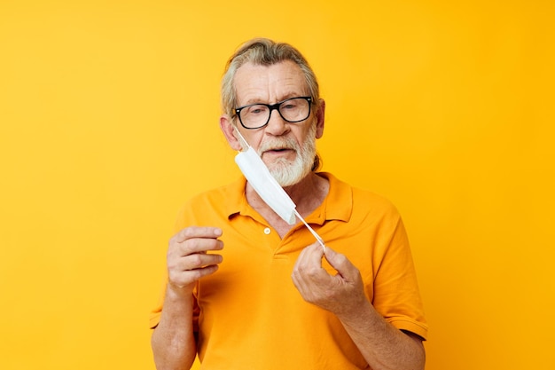 Máscara médica de velho na proteção facial closeup fundo amarelo