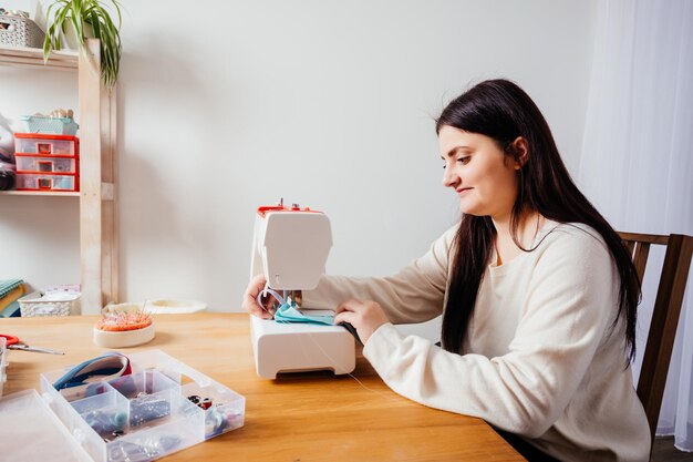 Máscara médica hecha a mano en máquina de coser moderna blanca