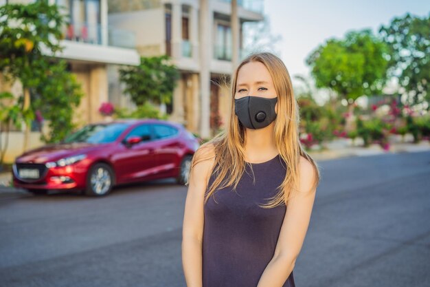 Máscara médica negra de moda con filtro en la ciudad concepto de epidemia de coronavirus ncov mujer en un