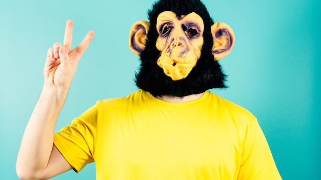 Máscara de mono Signo de paz Gesto camiseta amarilla Fondo azul