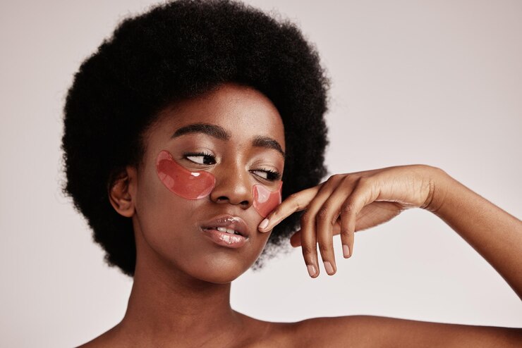 Foto máscara para os olhos de cuidados com a pele e uma mulher negra em estúdio com produto cosmético dermatológico modelo estético com mãos para adesivo de gel de colágeno para saúde, bem-estar e beleza rosto pele brilho em fundo cinza