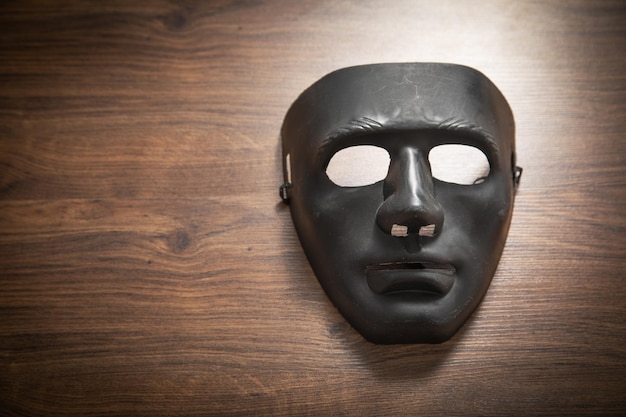 Máscara preta na mesa de madeira