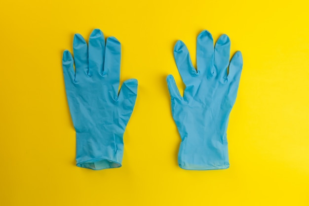 Foto máscara protectora y guantes sobre un fondo amarillo