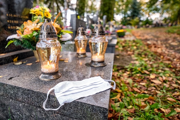 Máscara protetora na sepultura no cemitério Dia de Finados Vítima de coronavírus