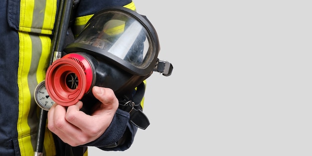 Foto máscara de respiración protectora completa en la mano de un bombero no reconocido