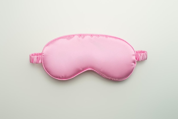 Máscara de sueño rosa sobre fondo blanco