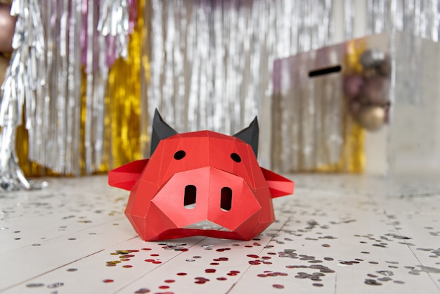 Máscara de toro de cartón rojo se encuentra en un piso plateado