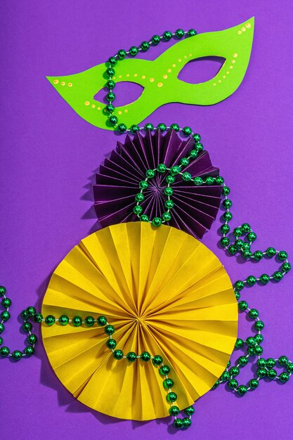 Foto mascarada festiva de mardi gras fondo púrpura máscaras de carnaval del martes gordo cuentas decoración tradicional colores simbólicos moda luz dura sombra oscura vista plana endecha superior