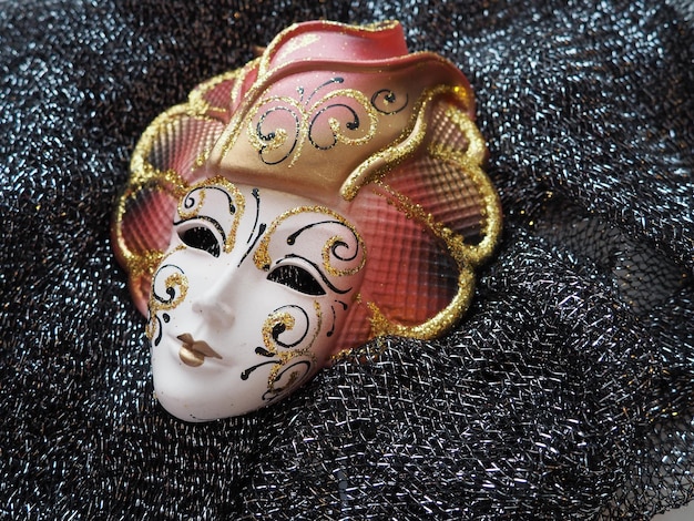 Foto máscaras de carnaval máscara em um lenço preto de lantejoulas elemento de fantasia de festival de carnaval italiano e veneziano