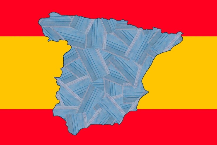 Foto máscaras médicas azuis no contexto da bandeira nacional da espanha